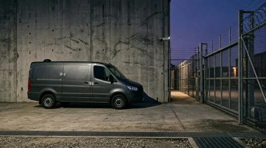 Fourgonnette d'artisan stationnée de nuit dans une zone sécurisée avec système de protection