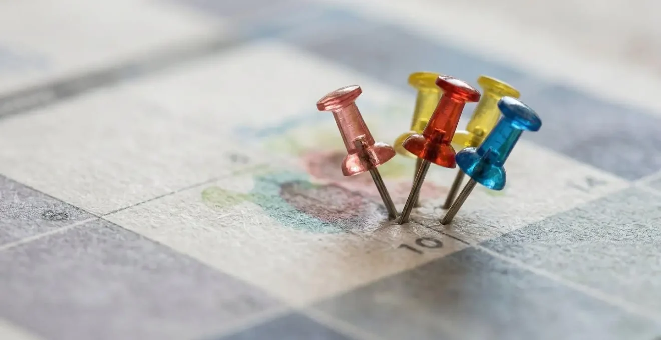 Vue macro d'un calendrier avec des marqueurs colorés indiquant les échéances de permis et les dates de vérification